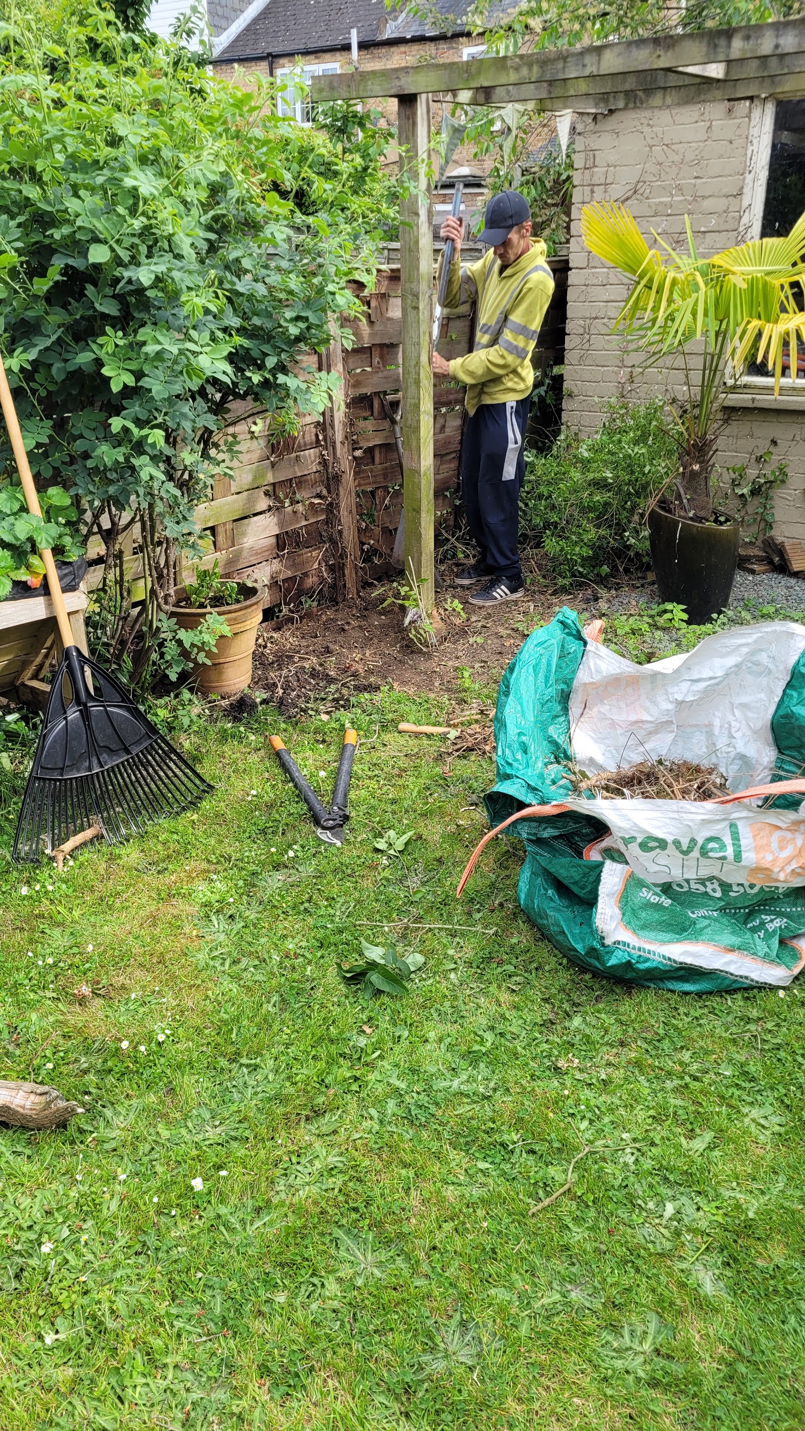 A Heartwood operative clearing overgrowth and green waste from a garden